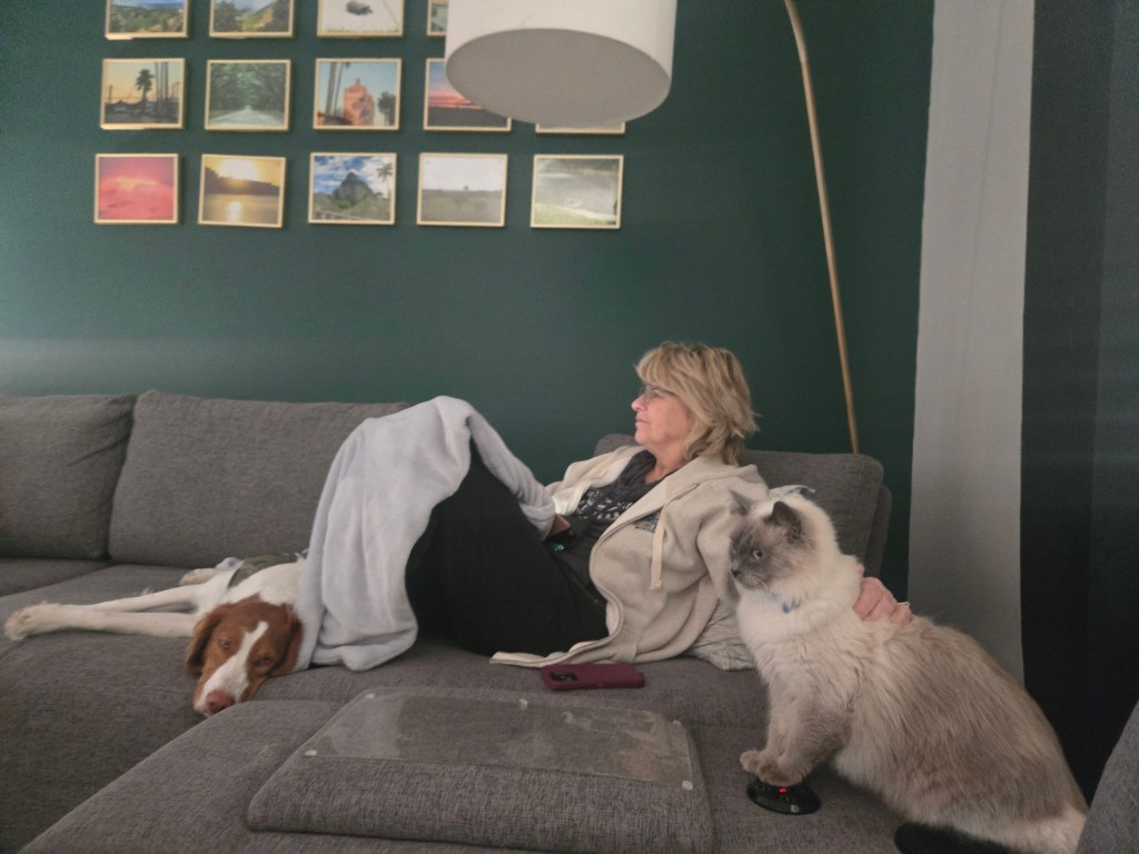 Laurie relaxing on couch with Goose(cat) and Rooster (dog) at the Savannah Airbnb