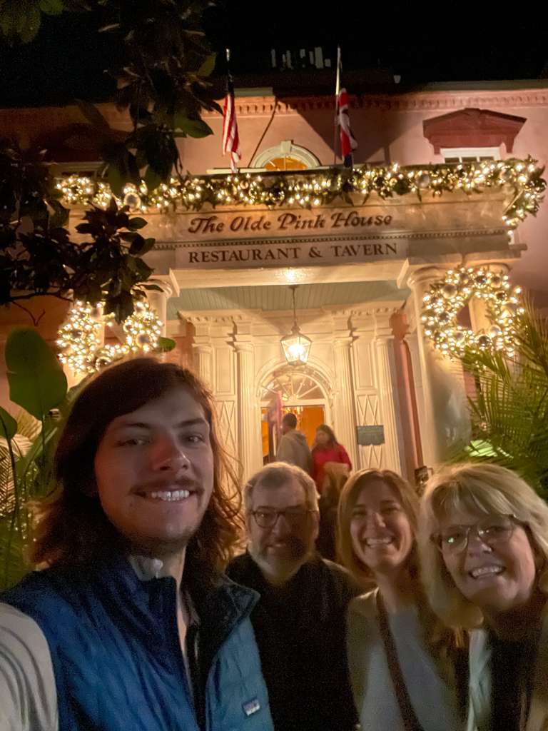 Ethan, Rob, Rebeca, and Laurie outside The Olde Pink House decorated with holiday lights