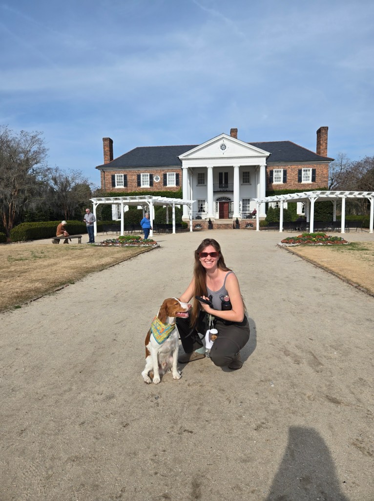 Rebeca and Rooster in front of Boone Hall Plantation mansion with 3 people in the background.