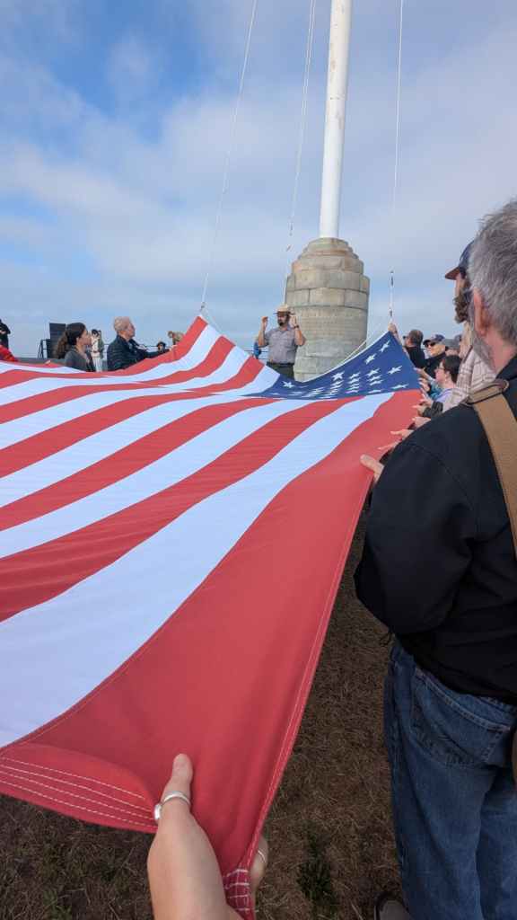 Visitors helping raise the American flag at Fort Sumter